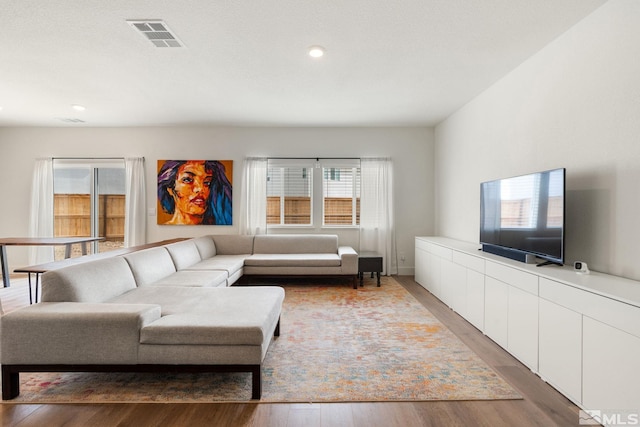 living room with recessed lighting, visible vents, and light wood-style floors