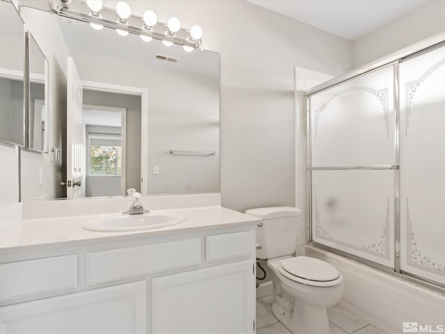 full bathroom with visible vents, toilet, vanity, and shower / bath combination with glass door