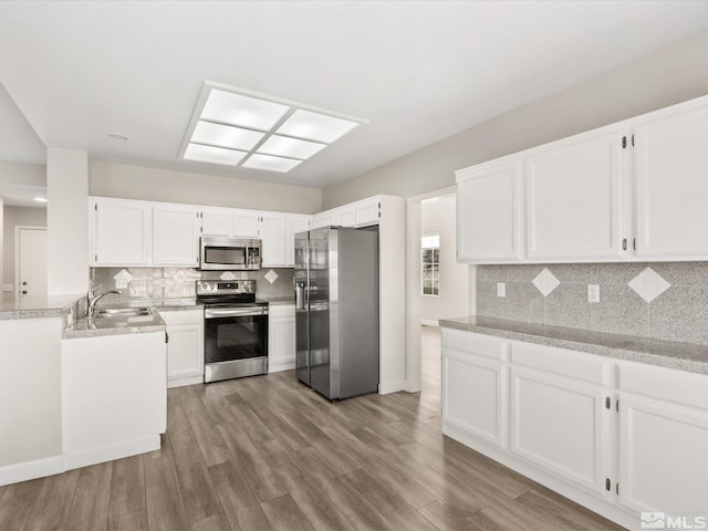 kitchen featuring a sink, appliances with stainless steel finishes, and white cabinetry