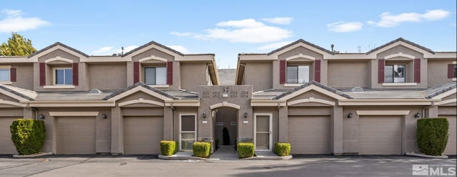 townhome / multi-family property featuring stucco siding, an attached garage, and a tile roof