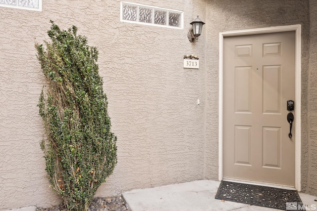 view of exterior entry featuring stucco siding