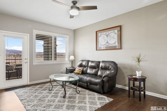 living room with wood finished floors, a healthy amount of sunlight, baseboards, and ceiling fan