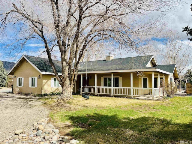 view of front of house featuring a porch, a front yard, and a chimney