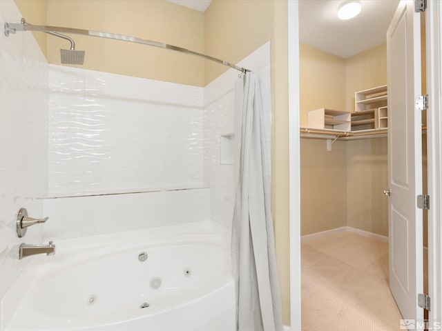 bathroom featuring a walk in closet and a combined bath / shower with jetted tub