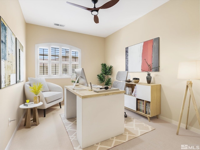 office featuring baseboards, light colored carpet, visible vents, and ceiling fan