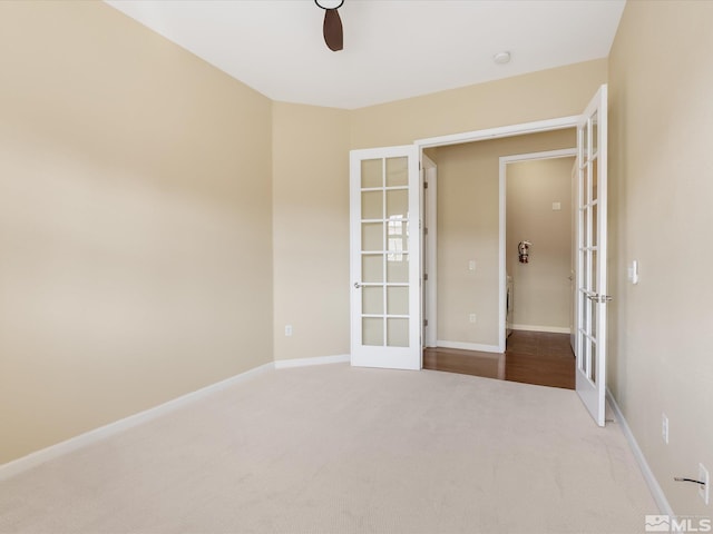 carpeted empty room with french doors, baseboards, and ceiling fan