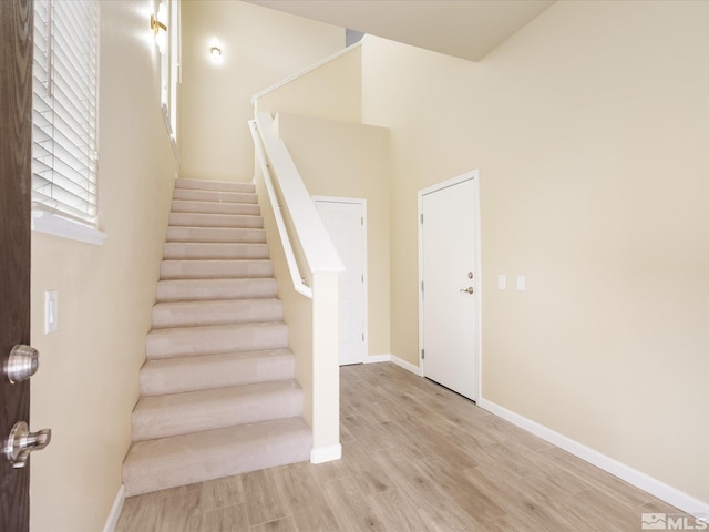 stairs with baseboards and wood finished floors