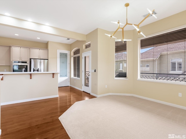 interior space featuring recessed lighting, wood finished floors, baseboards, and a chandelier