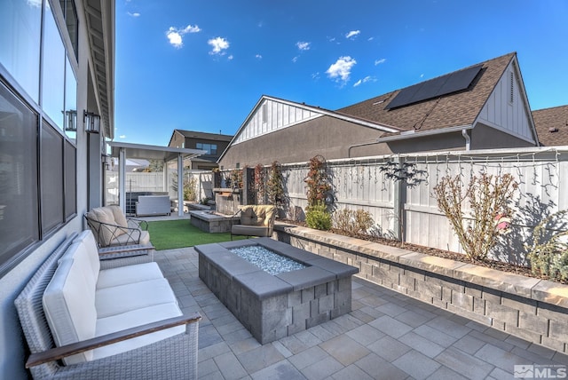 view of patio / terrace with an outdoor living space with a fire pit and a fenced backyard