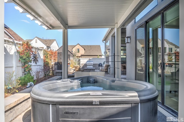 view of patio / terrace with fence, a residential view, and a hot tub