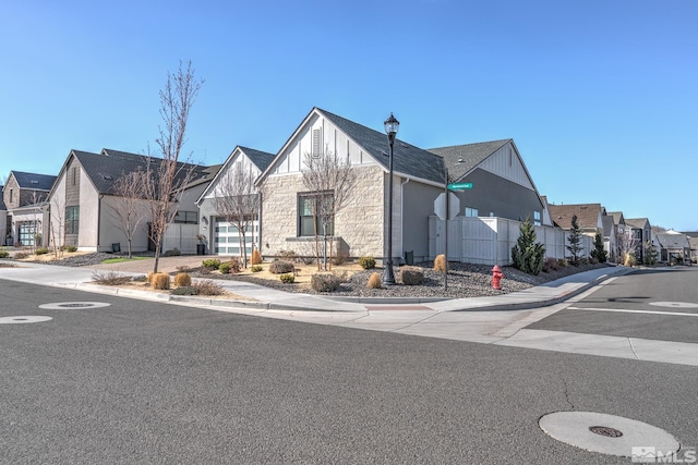 exterior space featuring fence, a residential view, and stone siding