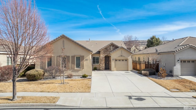 view of front of home featuring a tiled roof, a garage, driveway, and stucco siding