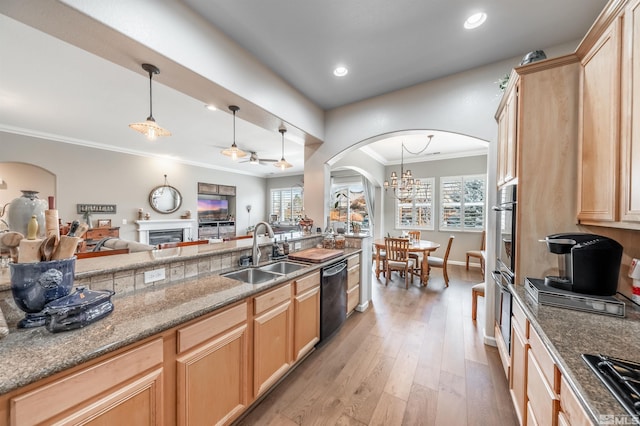 kitchen featuring light brown cabinets, dishwasher, and a sink