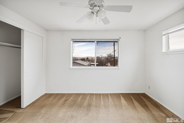 unfurnished bedroom featuring multiple windows, carpet, and a closet