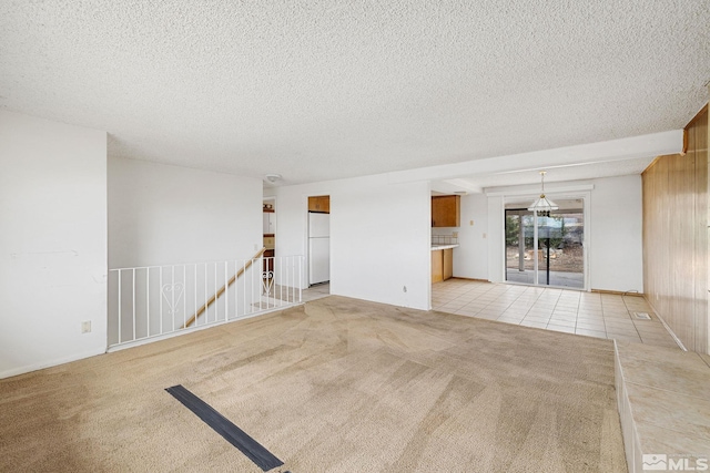 unfurnished living room featuring light colored carpet and a textured ceiling