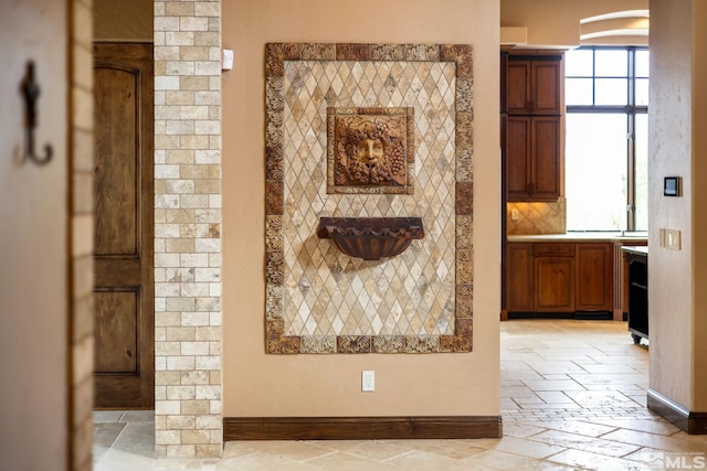 interior details with tasteful backsplash, arched walkways, and baseboards