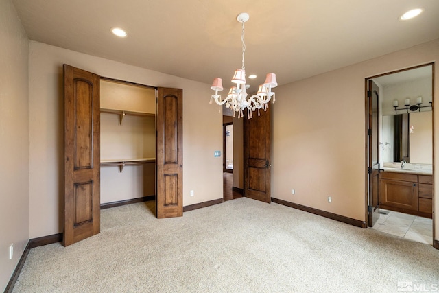 unfurnished bedroom featuring baseboards, recessed lighting, a closet, light colored carpet, and a chandelier