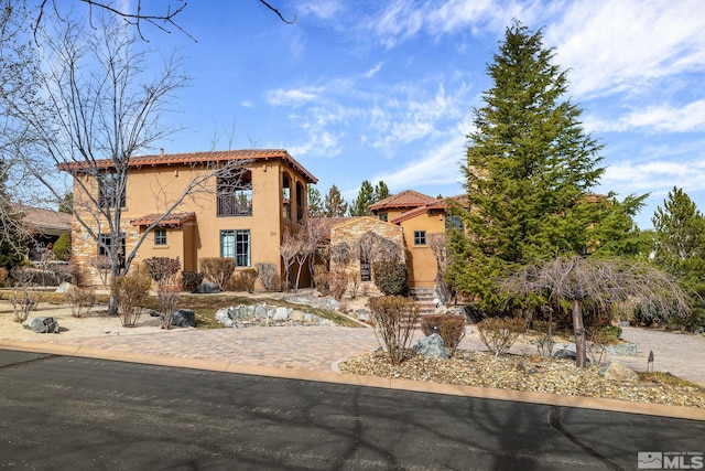 mediterranean / spanish-style home with stucco siding and a tiled roof