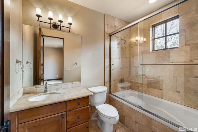 full bath with toilet, vanity, and tiled shower / bath combo