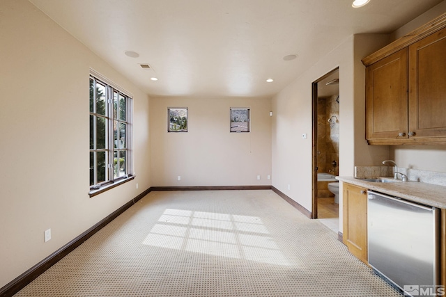 kitchen featuring visible vents, a sink, light countertops, baseboards, and dishwasher