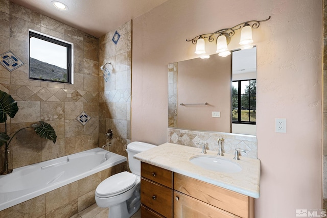 full bath featuring toilet, vanity, and tiled shower / bath