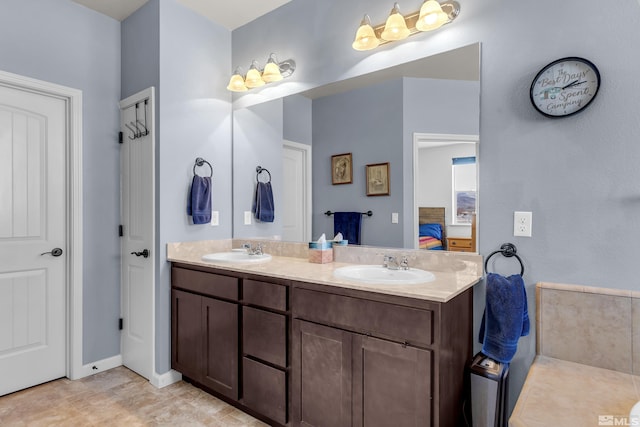 bathroom with a sink, double vanity, and connected bathroom