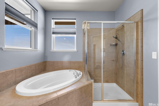 bathroom featuring a garden tub and a shower stall