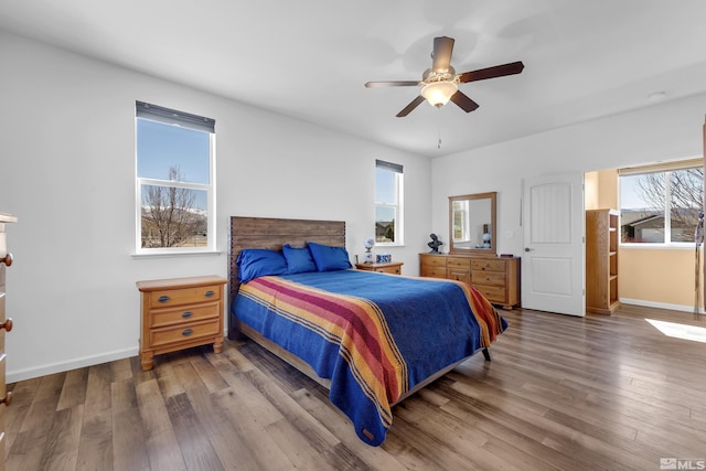 bedroom with a ceiling fan, baseboards, and wood finished floors