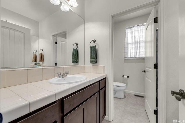 bathroom featuring visible vents, toilet, tile patterned flooring, baseboards, and vanity