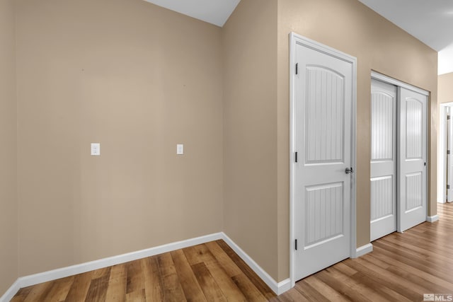 hallway with wood finished floors and baseboards