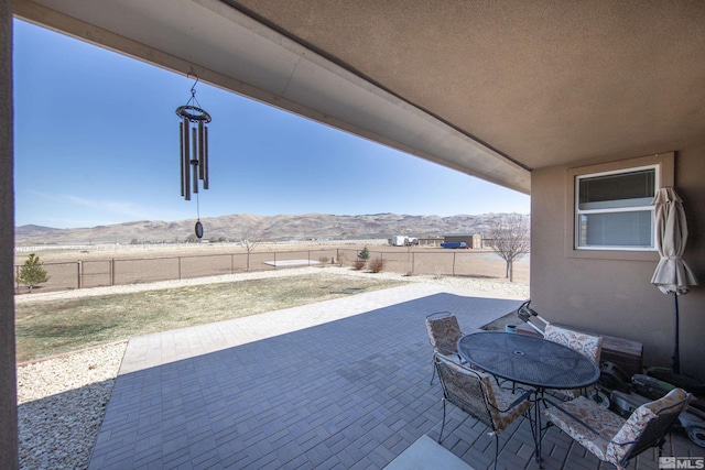 view of patio / terrace with a mountain view, a fenced backyard, and outdoor dining space