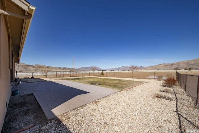 view of yard with a mountain view, a patio, and a fenced backyard