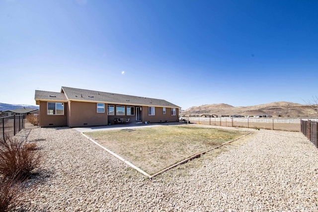 back of house featuring crawl space, a patio, a fenced backyard, and a mountain view