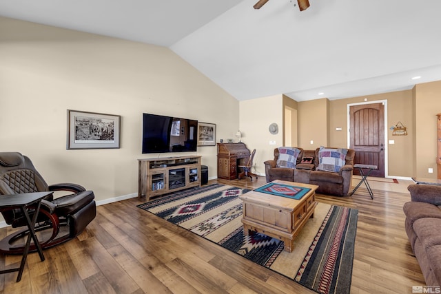 living room featuring vaulted ceiling, wood finished floors, baseboards, and ceiling fan