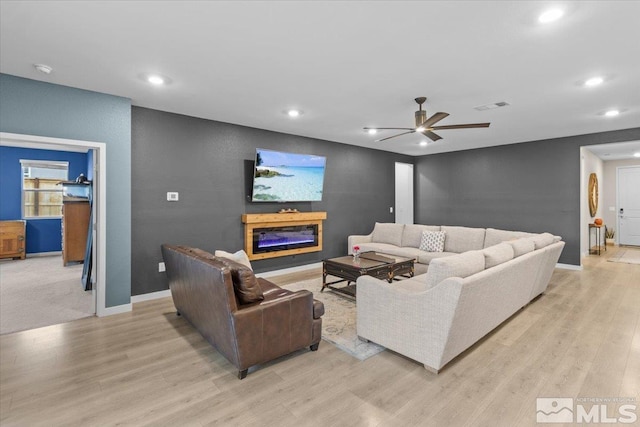 living area featuring visible vents, a ceiling fan, recessed lighting, light wood-style floors, and baseboards