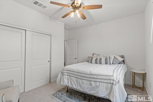 bedroom featuring visible vents, baseboards, ceiling fan, light carpet, and a closet