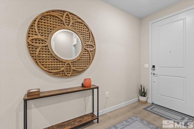 foyer entrance with baseboards and light wood-type flooring