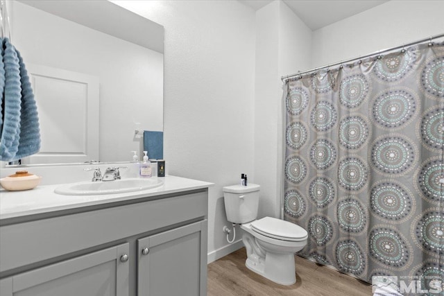 full bath with vanity, a shower with shower curtain, toilet, and wood finished floors