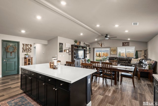 kitchen featuring visible vents, lofted ceiling with beams, dark wood-style floors, dark cabinets, and ceiling fan