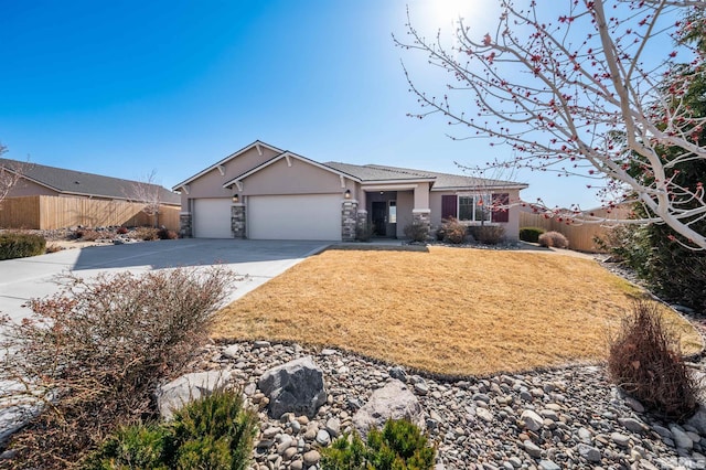 view of front of home featuring a front lawn, fence, concrete driveway, stucco siding, and a garage