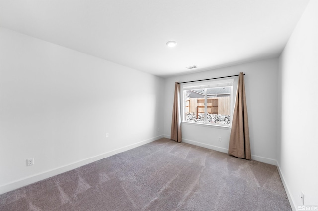 spare room featuring visible vents, baseboards, and carpet floors