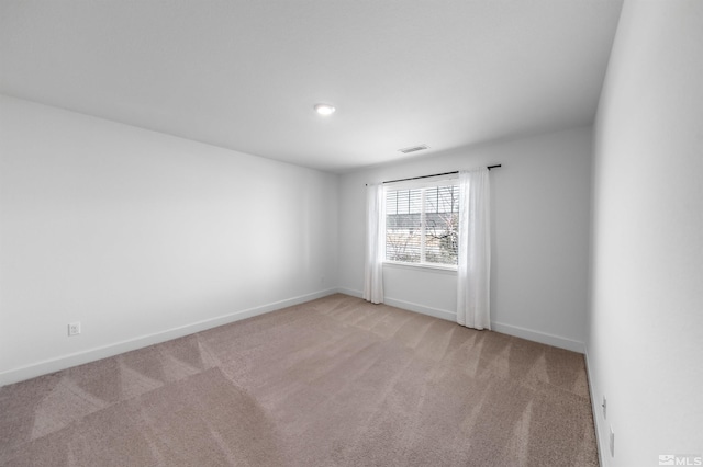 spare room with carpet flooring, baseboards, and visible vents