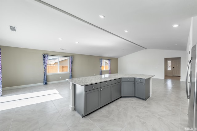 kitchen featuring visible vents, gray cabinets, a kitchen island, open floor plan, and lofted ceiling