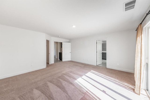 unfurnished bedroom with light colored carpet, visible vents, and baseboards