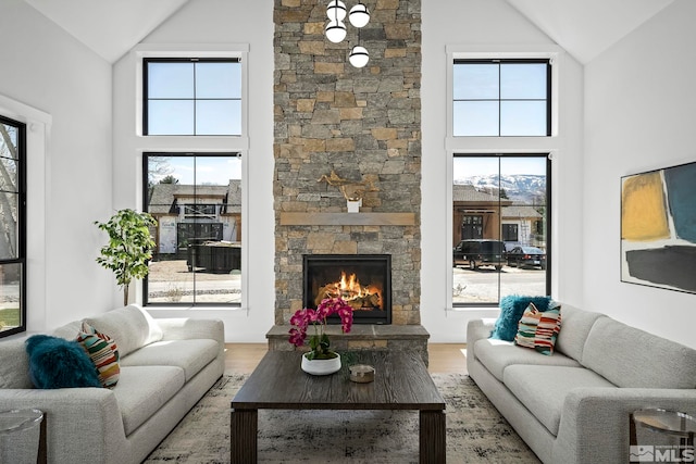 living room featuring a fireplace, wood finished floors, and high vaulted ceiling