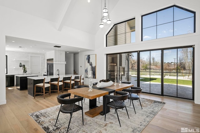 dining room featuring beam ceiling, recessed lighting, high vaulted ceiling, and light wood-style floors