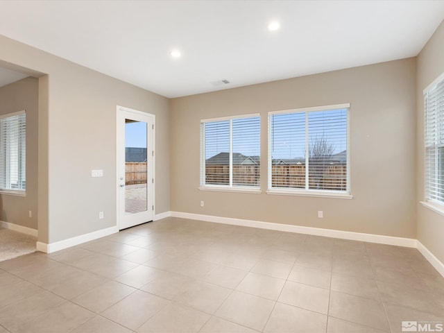 empty room featuring plenty of natural light, recessed lighting, and baseboards