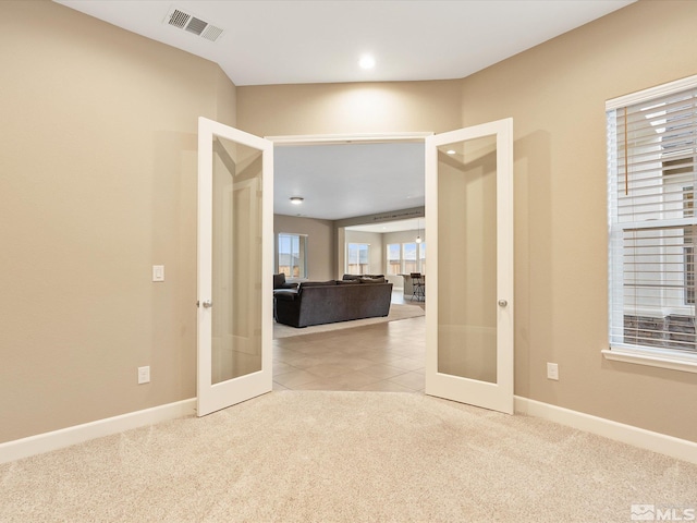 carpeted empty room with french doors, baseboards, and visible vents