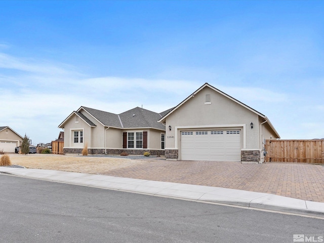 ranch-style house with stone siding, stucco siding, decorative driveway, and fence