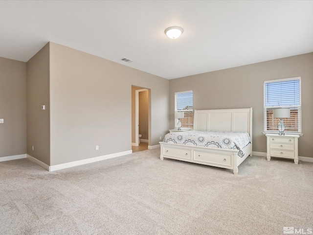 bedroom with visible vents, multiple windows, and light colored carpet